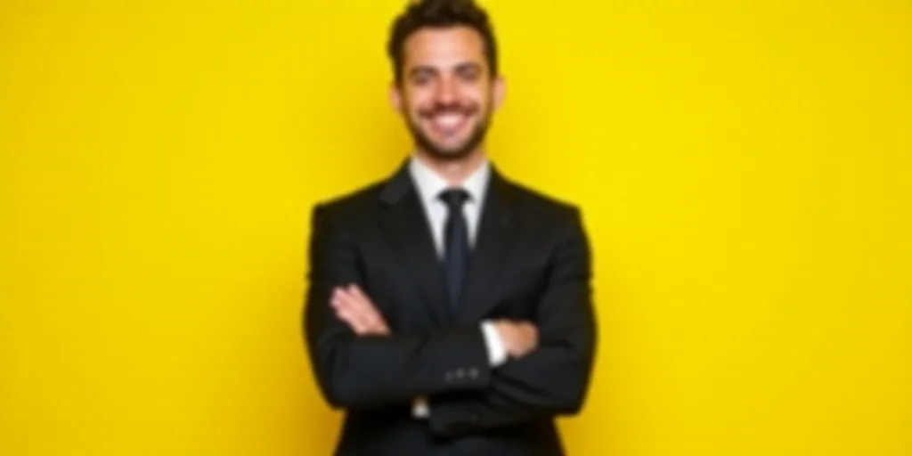 a man in a suit standing with his arms crossed and smiling at the camera with his arms crossed, with