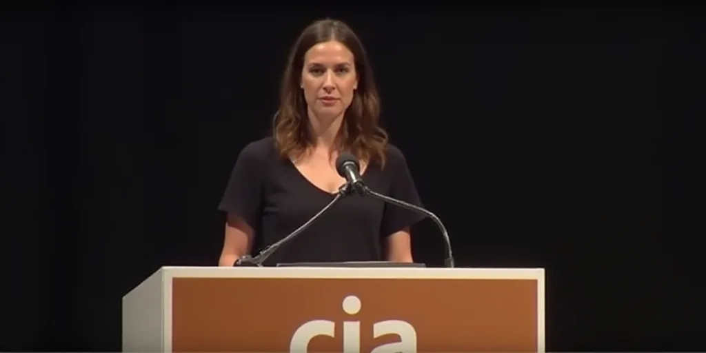 a woman standing at a podium with a microphone in front of her and a sign behind her that says cia,
