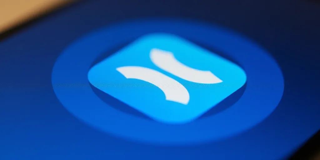 a close up of a blue and white logo on a cell phone with a blue background and a blue circle, Ai-Mit