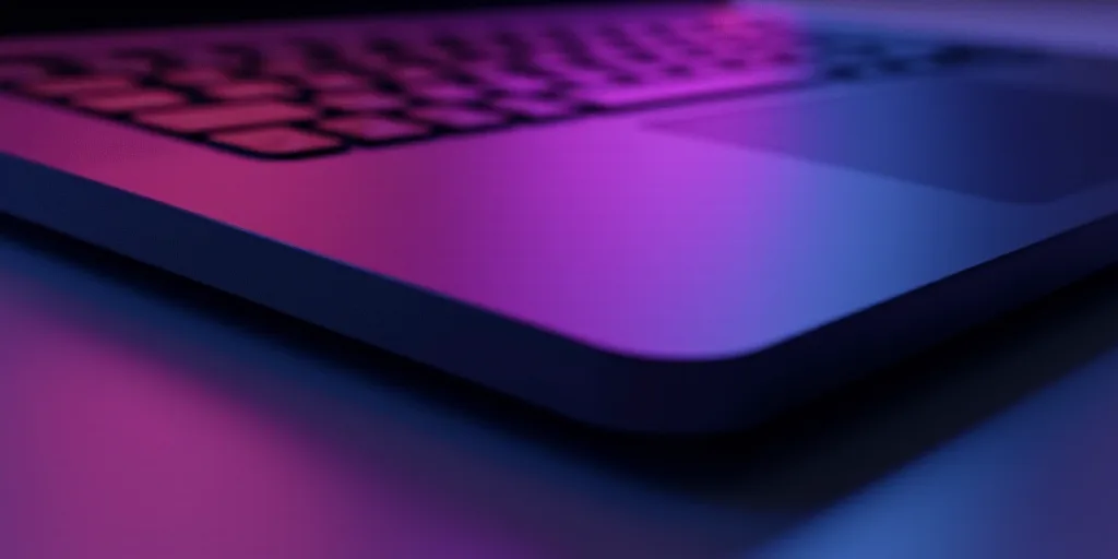 a close up of a laptop keyboard with a logo on it's side and a purple light shining on the keyboard,