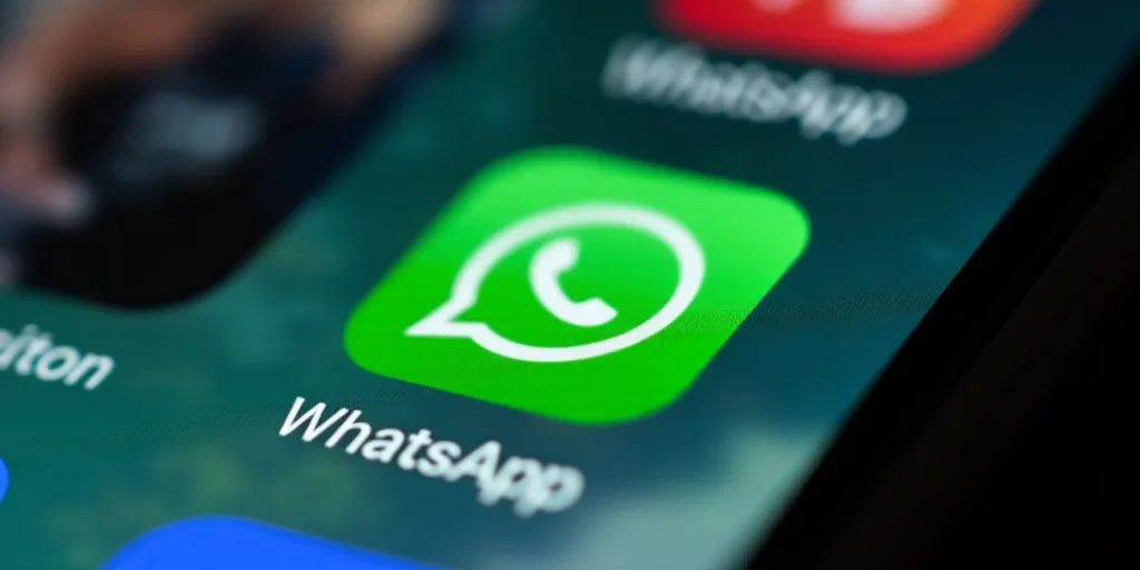 whatsapp logo on a phone screen with other phone screens in the background and a blurry image of wha