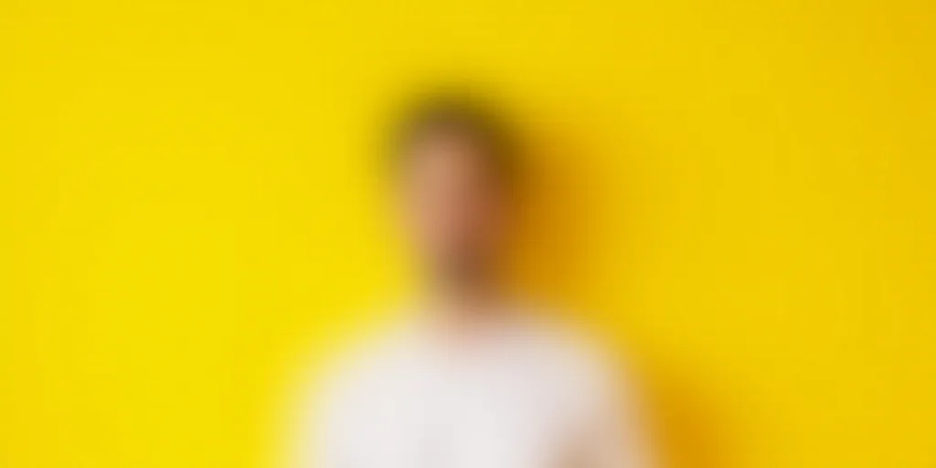 a man in a white shirt and a yellow background with a yellow background and a yellow background with