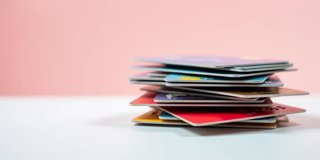 a stack of credit cards stacked on top of each other on a table with a white background and a red on